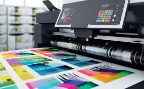 Impresora industrial a color produciendo impresiones de alta calidad con diseños vibrantes en una planta de impresión.
